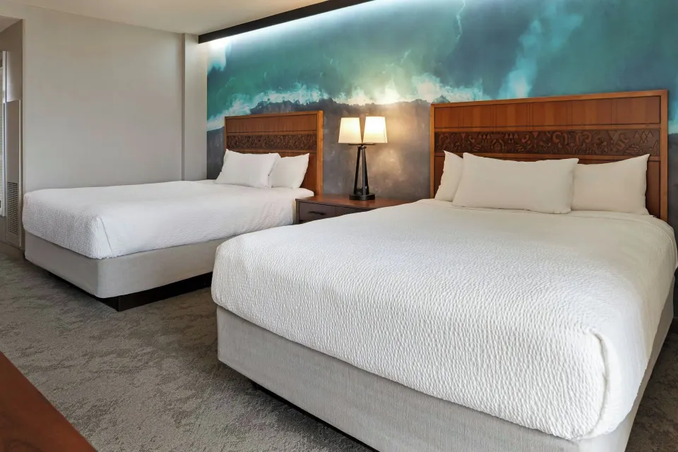 Two-bed guest room with ocean mural at Courtyard King Kamehameha's Kona Beach Hotel.