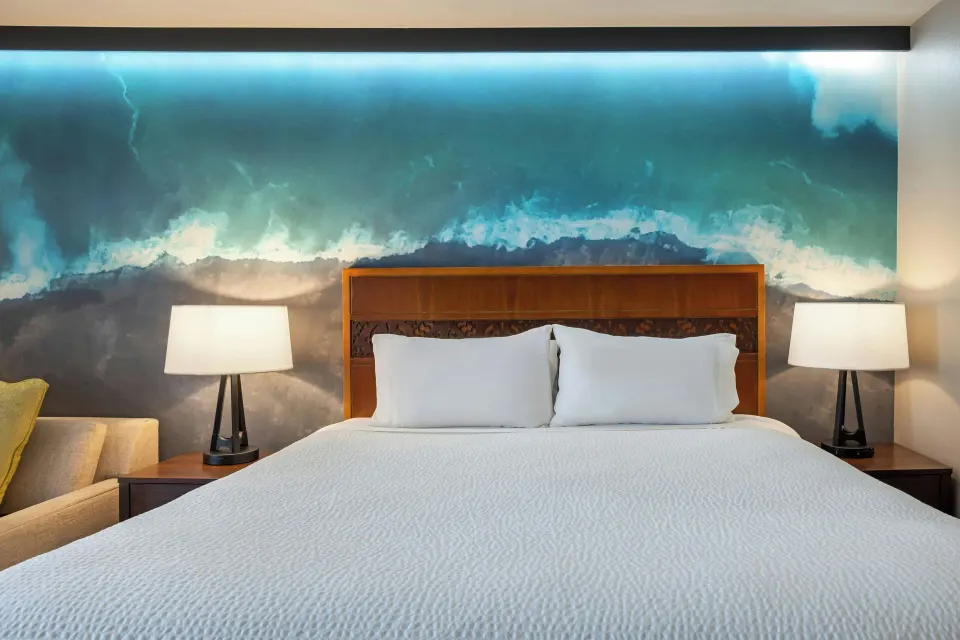 King bed with mural wall at Courtyard King Kamehameha's Kona Beach Hotel.