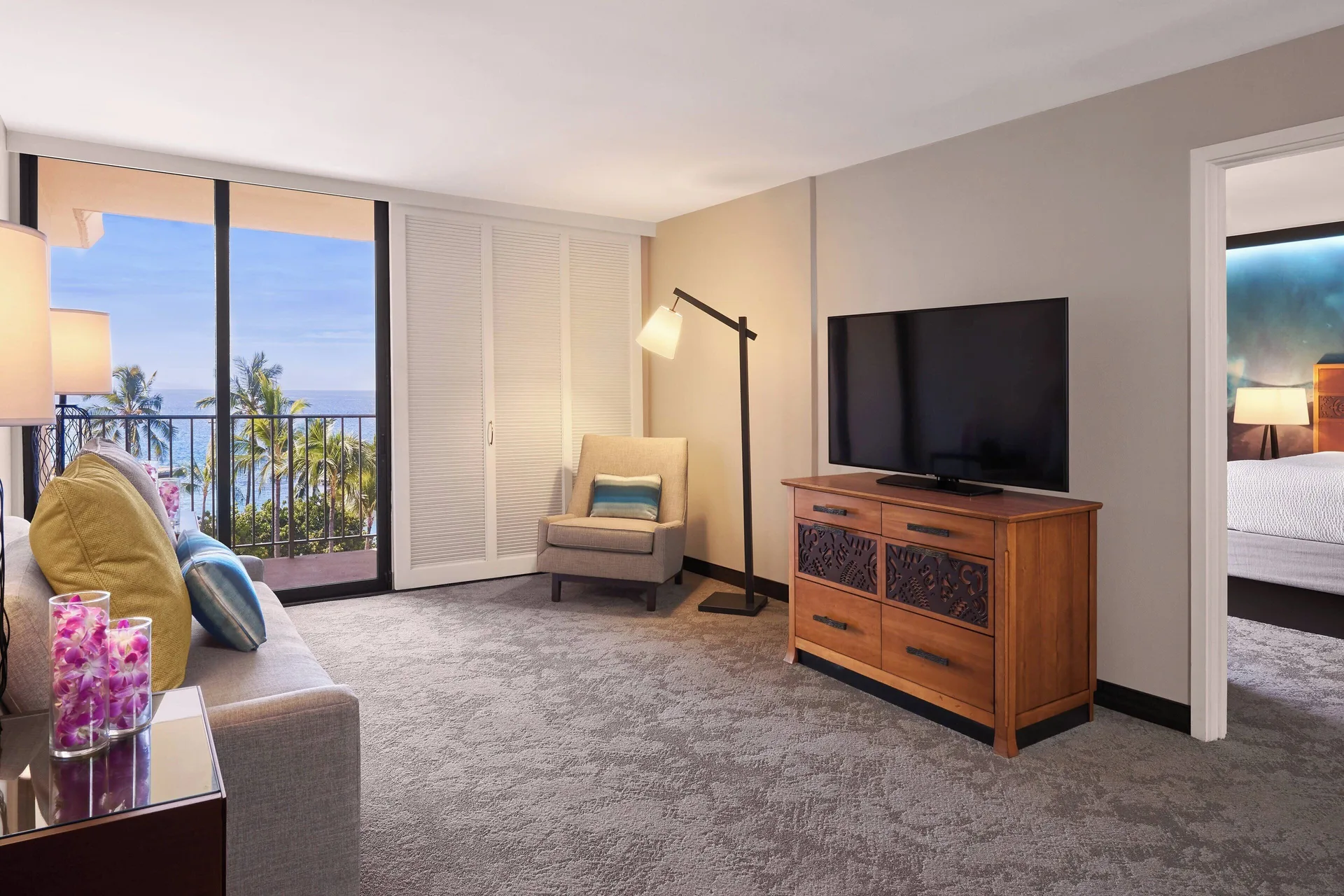 Living area and bedroom doorway in an oceanfront suite at Courtyard King Kamehameha's Kona Beach Hotel.