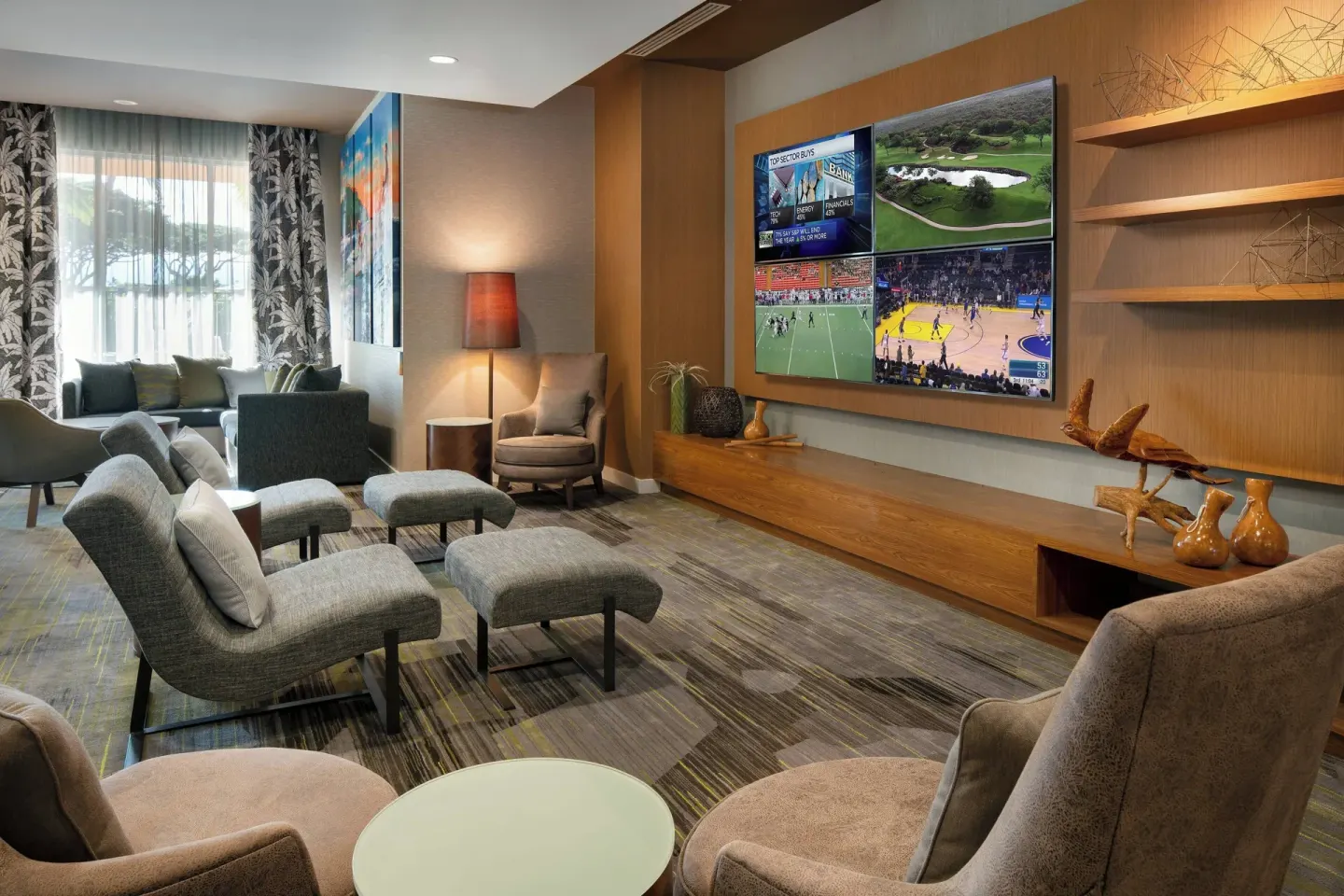 Lobby lounge with chairs and a large television wall at Courtyard Maui Kahului Airport.