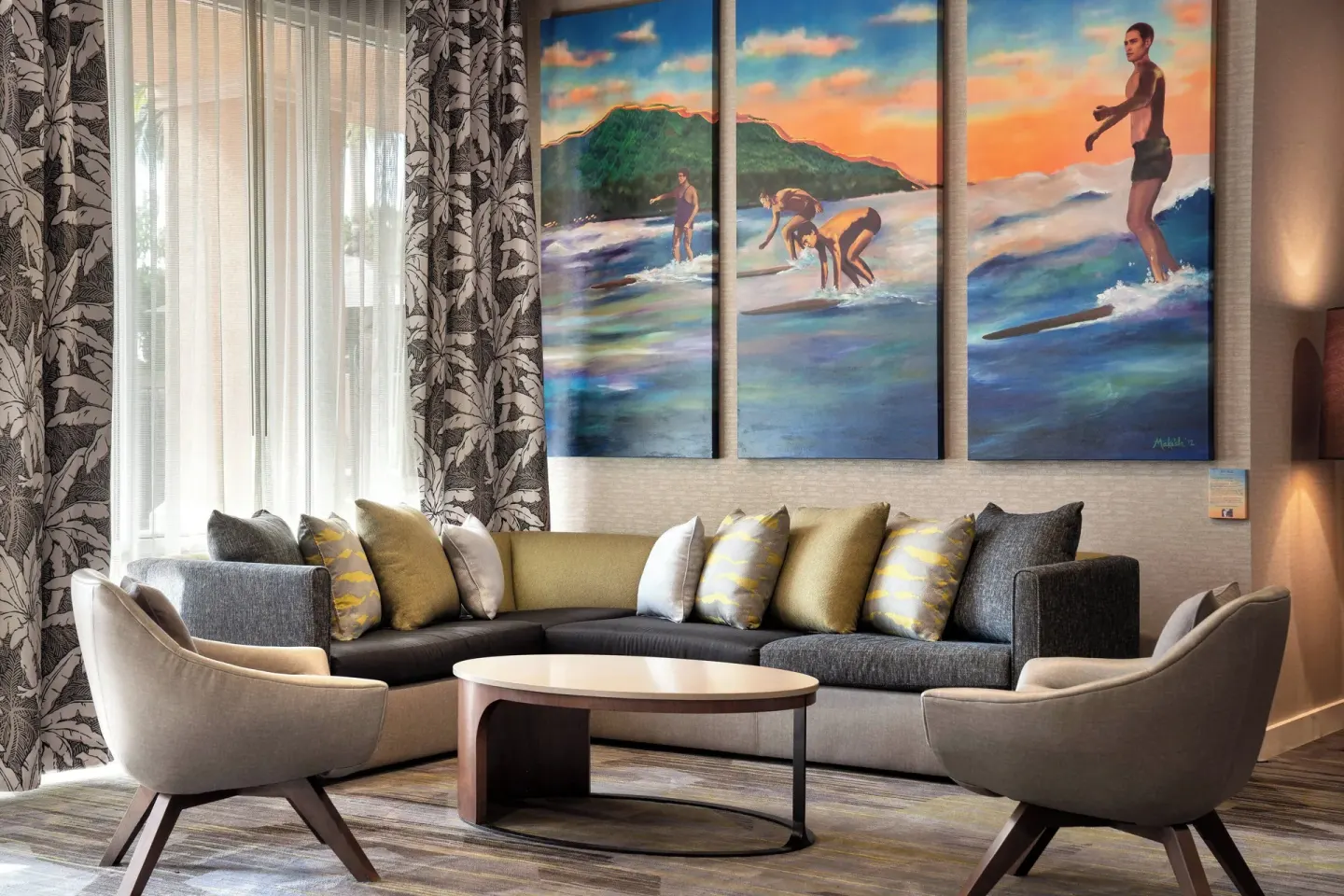 Lobby seating area with surf artwork at Courtyard Maui Kahului Airport.