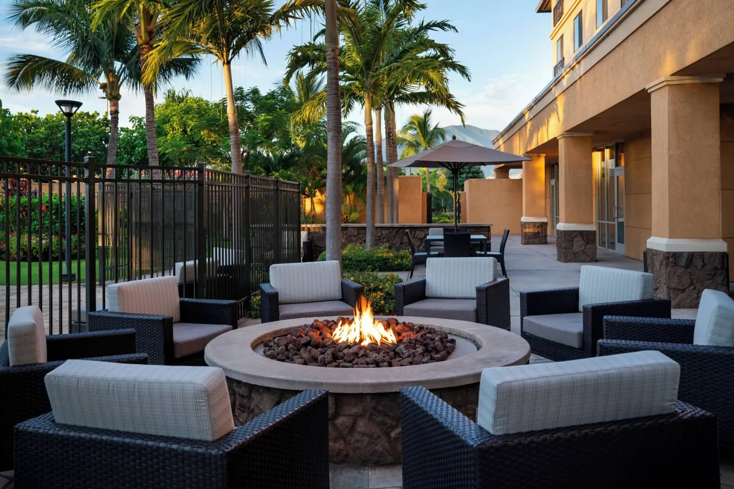 Outdoor fire pit lounge with cushioned seating at Courtyard Maui Kahului Airport.