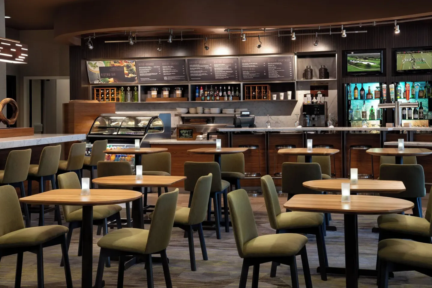 Dining area with round tables and a bar counter at Courtyard Maui Kahului Airport.