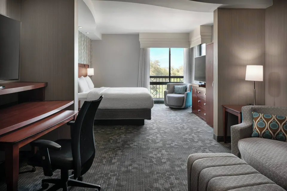 Junior room with king bed, sofa bed, desk, and window at Courtyard Maui Kahului Airport.