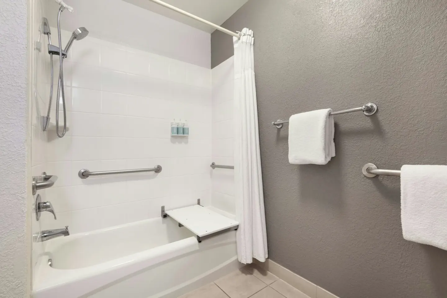 Accessible bathtub with shower and towels in a room at Courtyard Maui Kahului Airport.