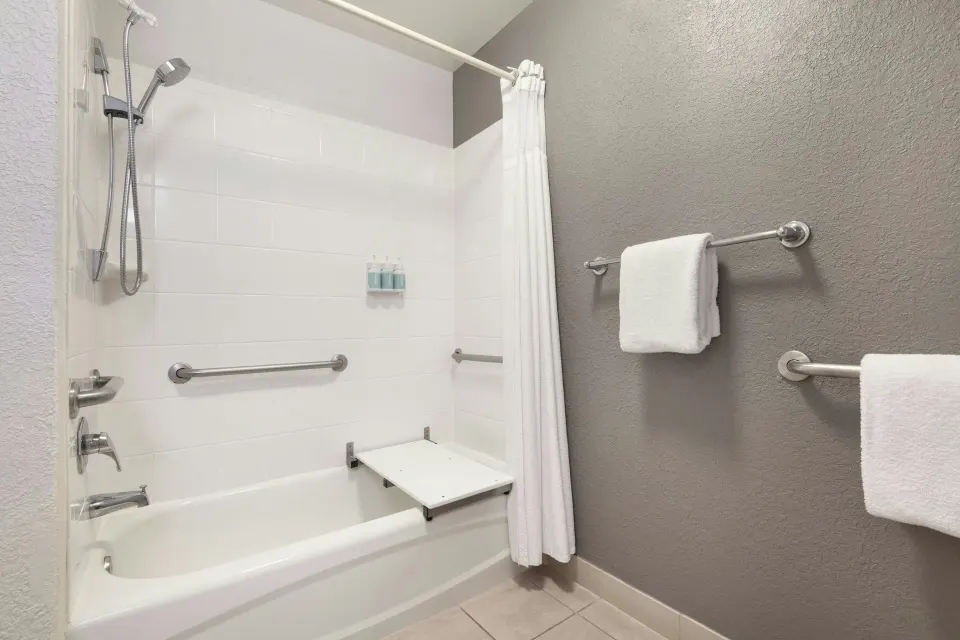 Accessible bathtub with shower and towels in a room at Courtyard Maui Kahului Airport.