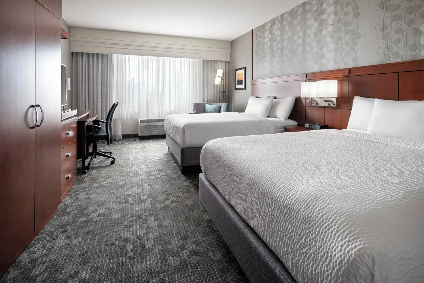 Guest room with two queen beds and a work desk at Courtyard Maui Kahului Airport.