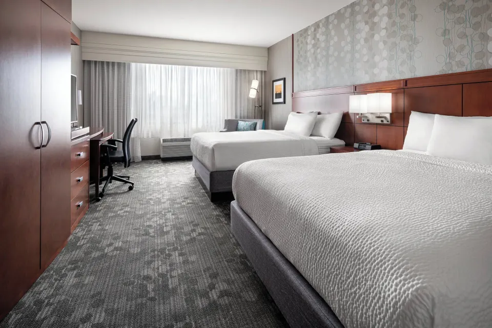 Guest room with two queen beds and a work desk at Courtyard Maui Kahului Airport.