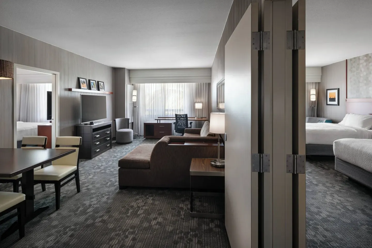 Suite living area and bedroom with king bed at Courtyard Maui Kahului Airport.