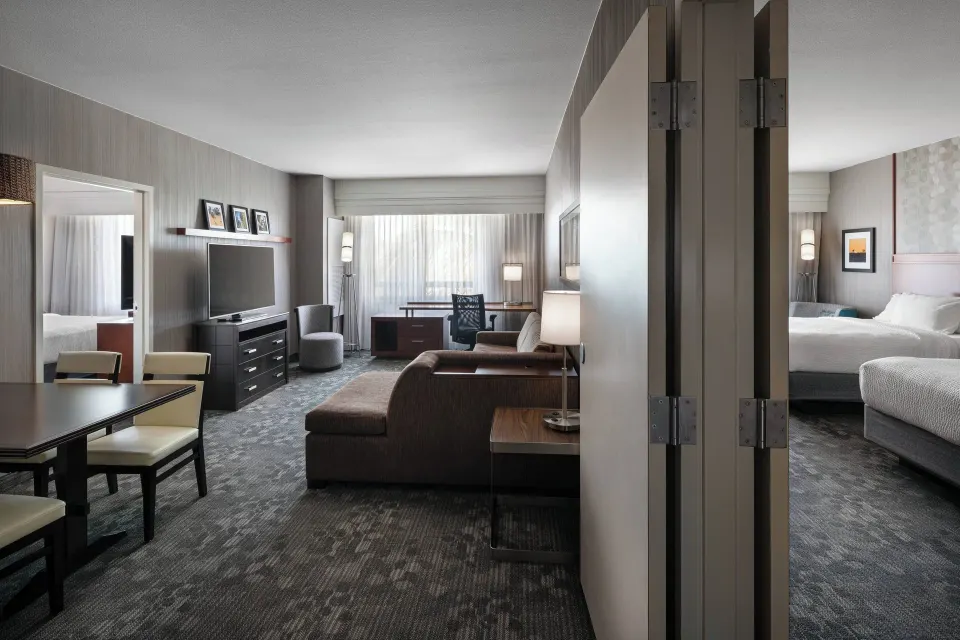 Suite living area and bedroom with king bed at Courtyard Maui Kahului Airport.
