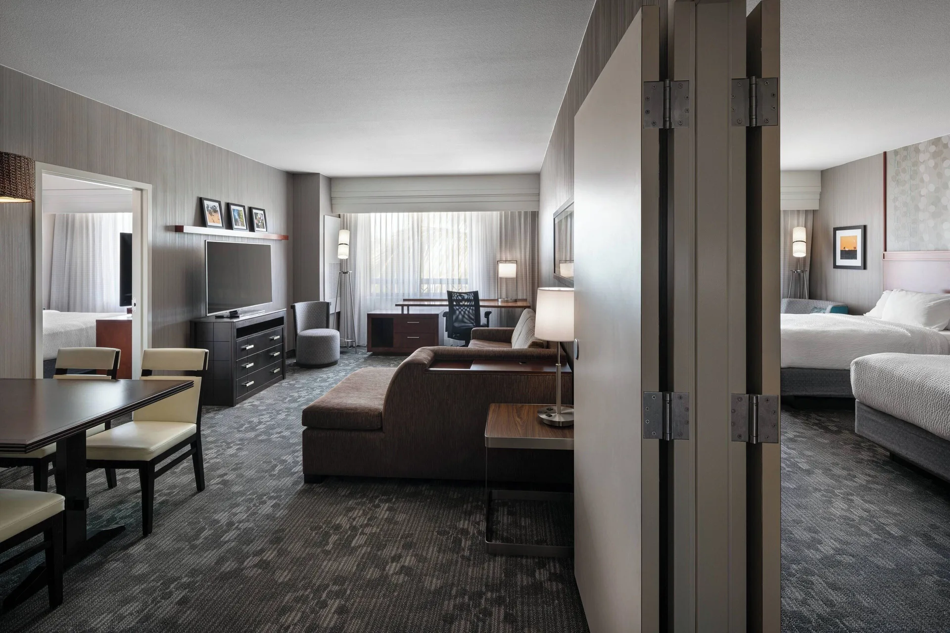 Suite living area and bedroom with king bed at Courtyard Maui Kahului Airport.