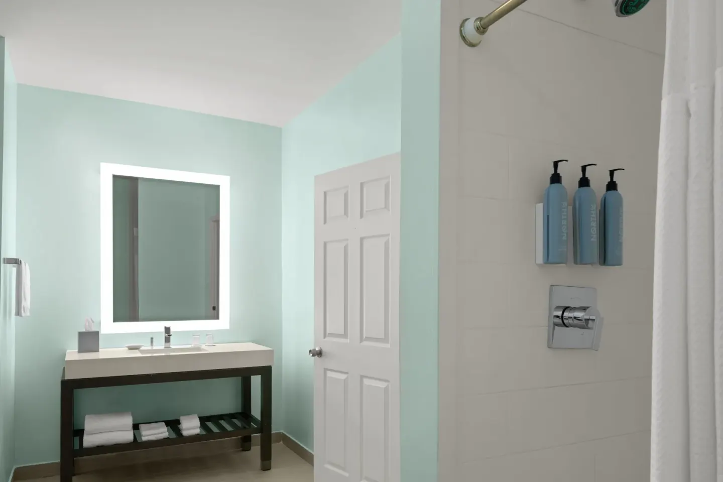 Guest bathroom shower and vanity at Courtyard Nassau Downtown/Junkanoo Beach.