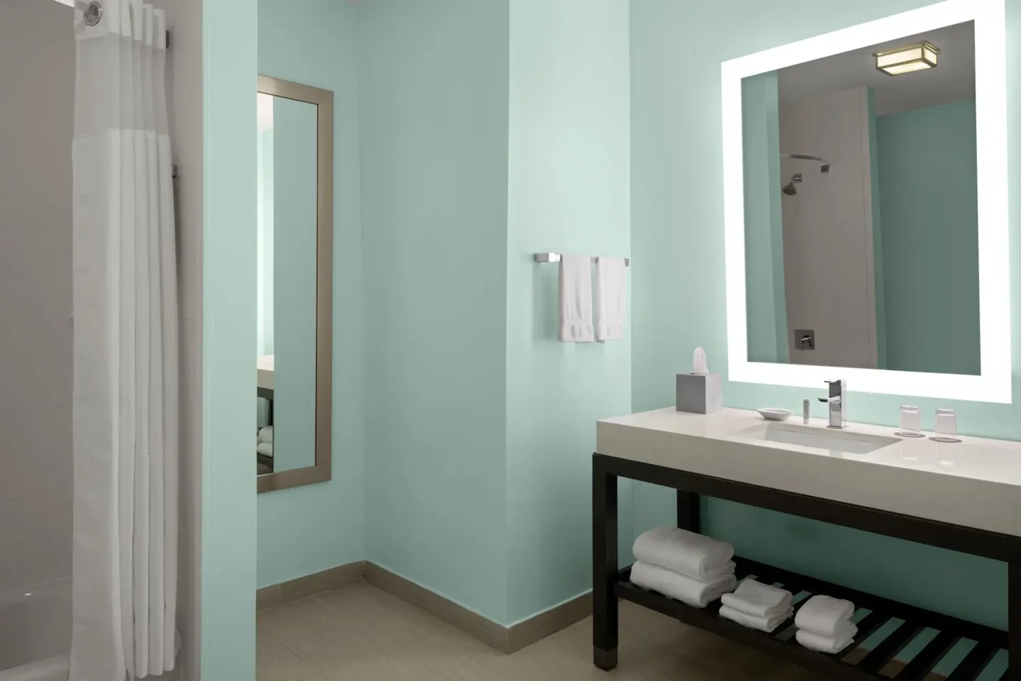 Guest bathroom vanity and shower at Courtyard Nassau Downtown/Junkanoo Beach.