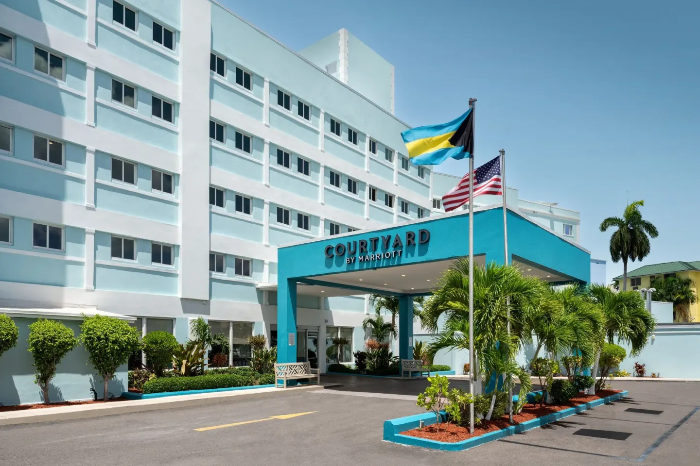 Hotel entrance with flags at Courtyard Nassau Downtown/Junkanoo Beach.