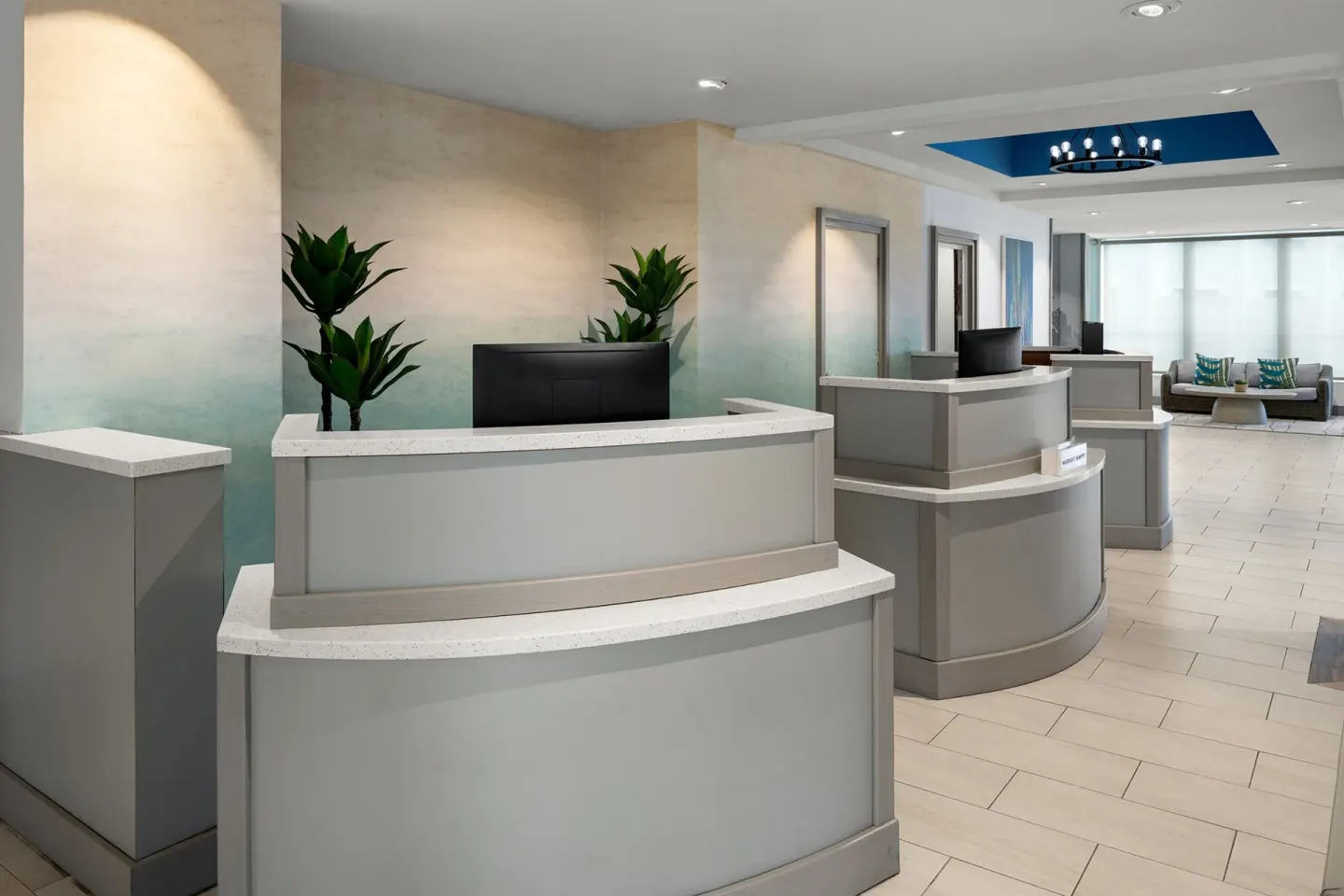 Reception desks at Courtyard Nassau Downtown/Junkanoo Beach with pale walls and tile flooring.