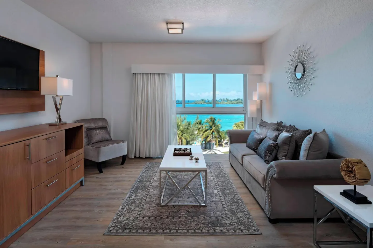 Suite living room at Courtyard Nassau Downtown/Junkanoo Beach with sofa and turquoise water view.