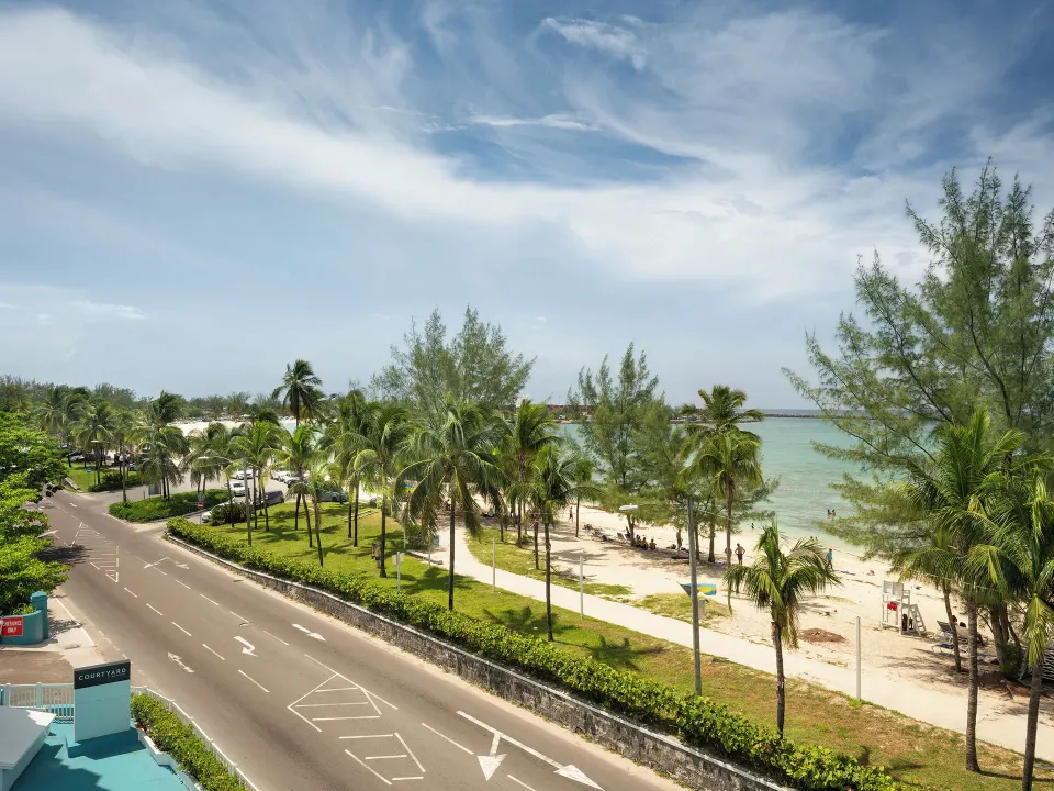 View of Junkanoo Beach and palm-lined road from Courtyard Nassau Downtown/Junkanoo Beach.