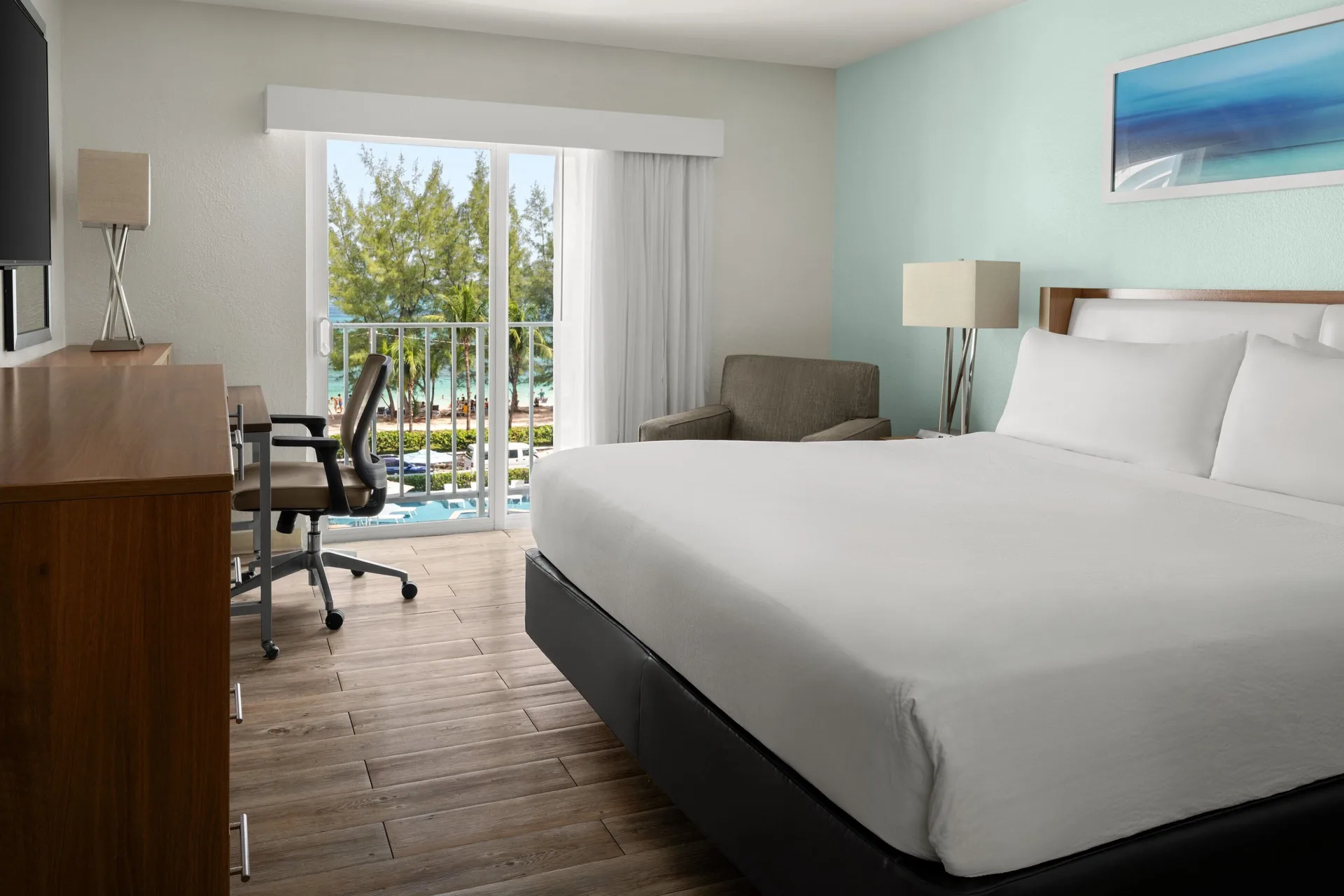 Oceanfront guest room with king bed, desk and balcony at Courtyard Nassau Downtown/Junkanoo Beach.