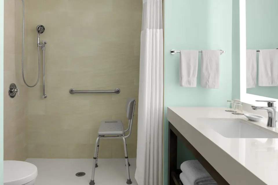 Accessible bathroom with roll-in shower at Courtyard Nassau Downtown/Junkanoo Beach.