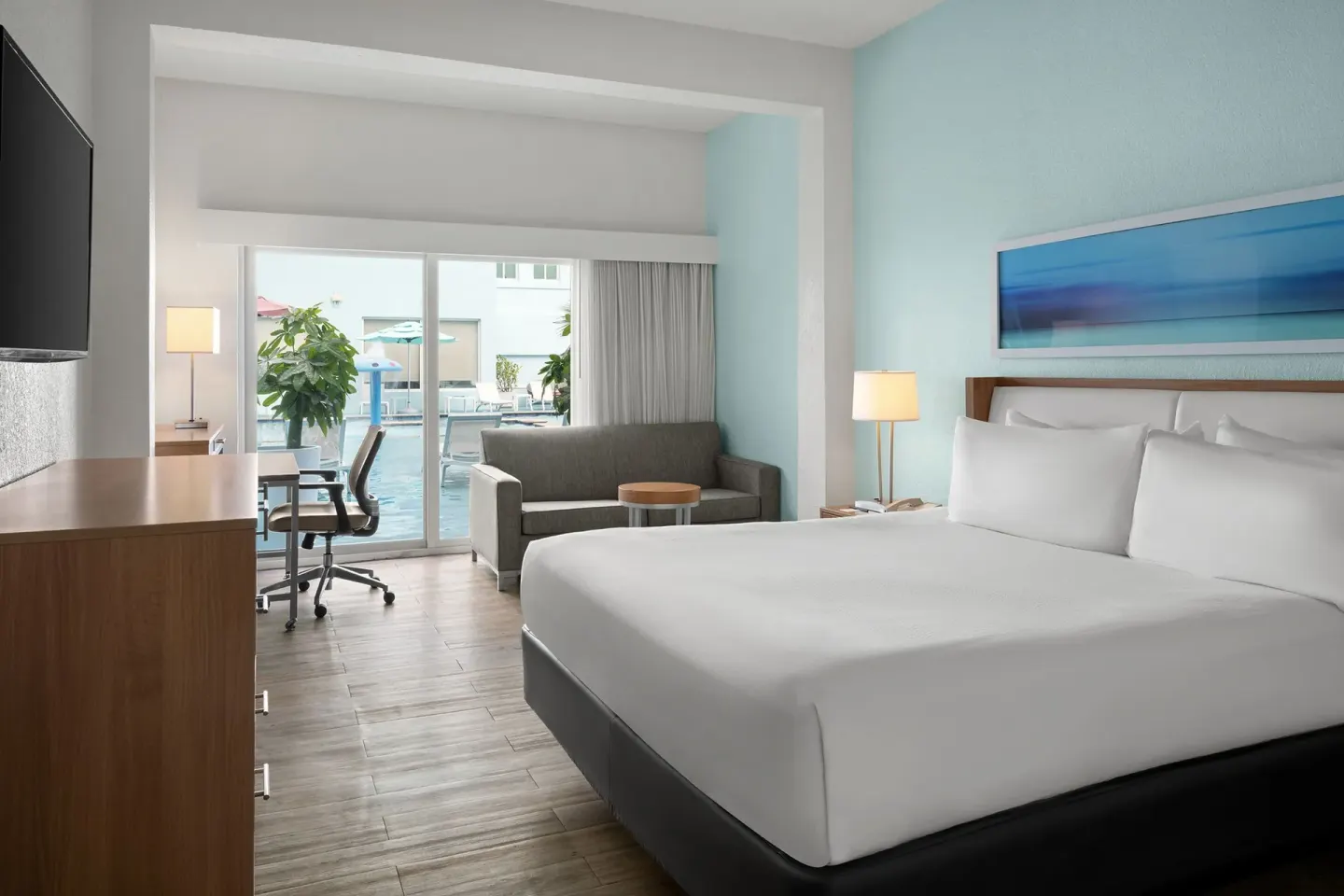 King guest room with poolside patio access at Courtyard Nassau Downtown/Junkanoo Beach.