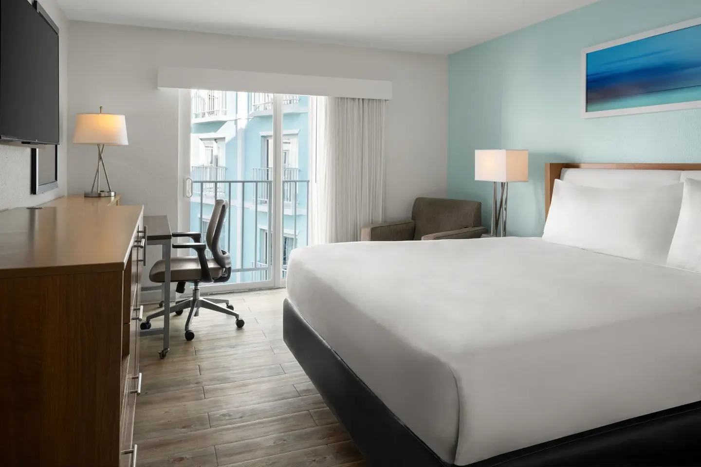 Standard room with a king bed and balcony door at Courtyard Nassau Downtown/Junkanoo Beach.