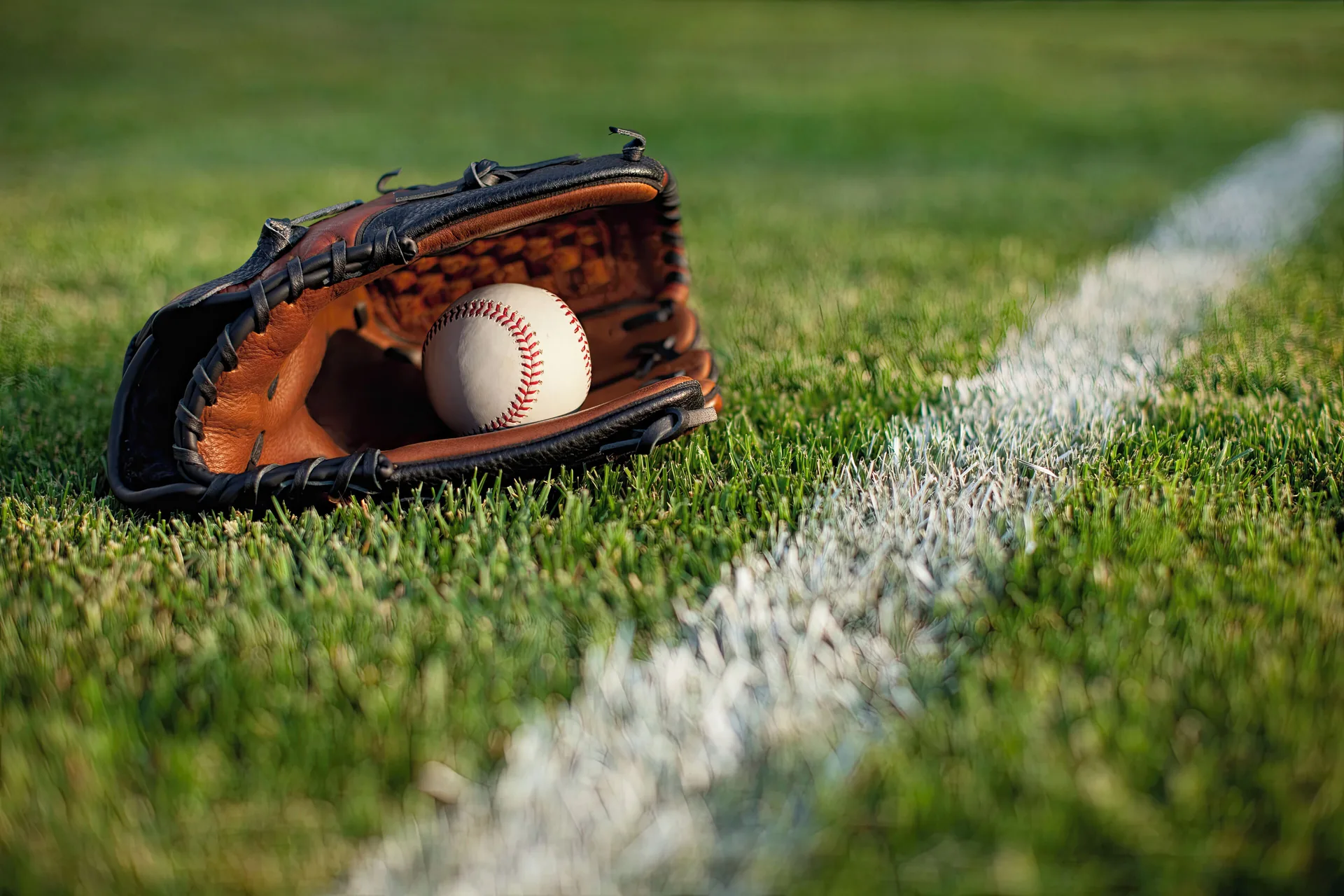 Baseball glove and ball on a grass field near Courtyard Oahu North Shore.