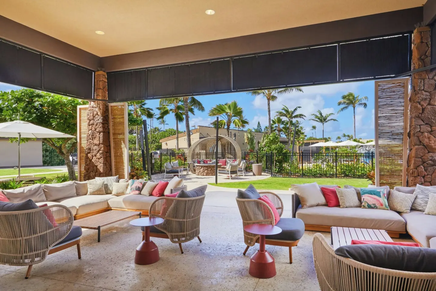 Covered outdoor lounge seating with tropical landscaping at Courtyard Oahu North Shore.