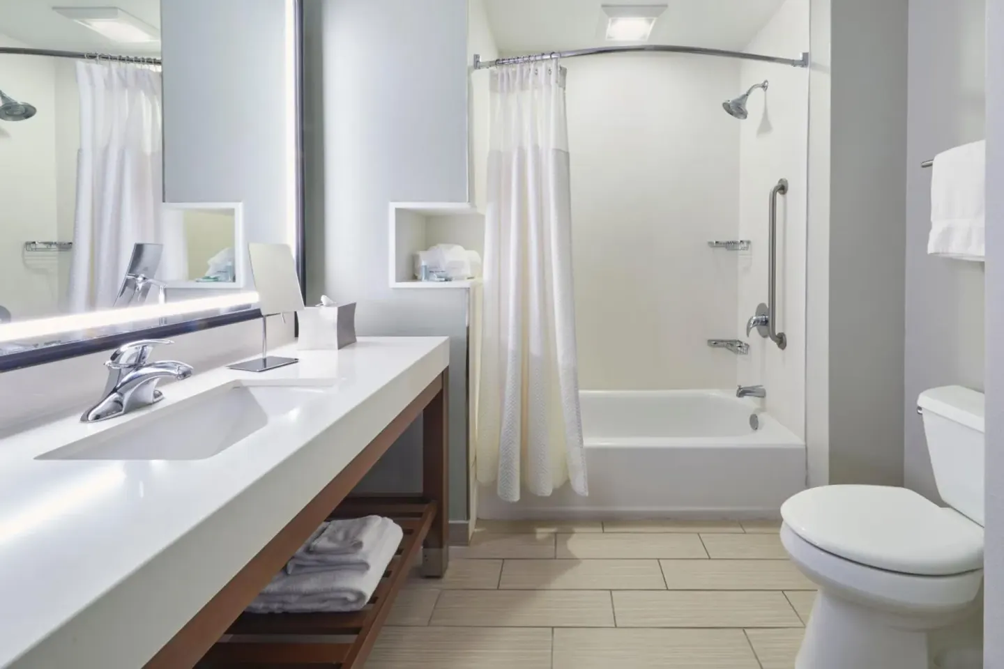 Guest bathroom with vanity, tub shower, curtain, and toilet at Courtyard Oahu North Shore.