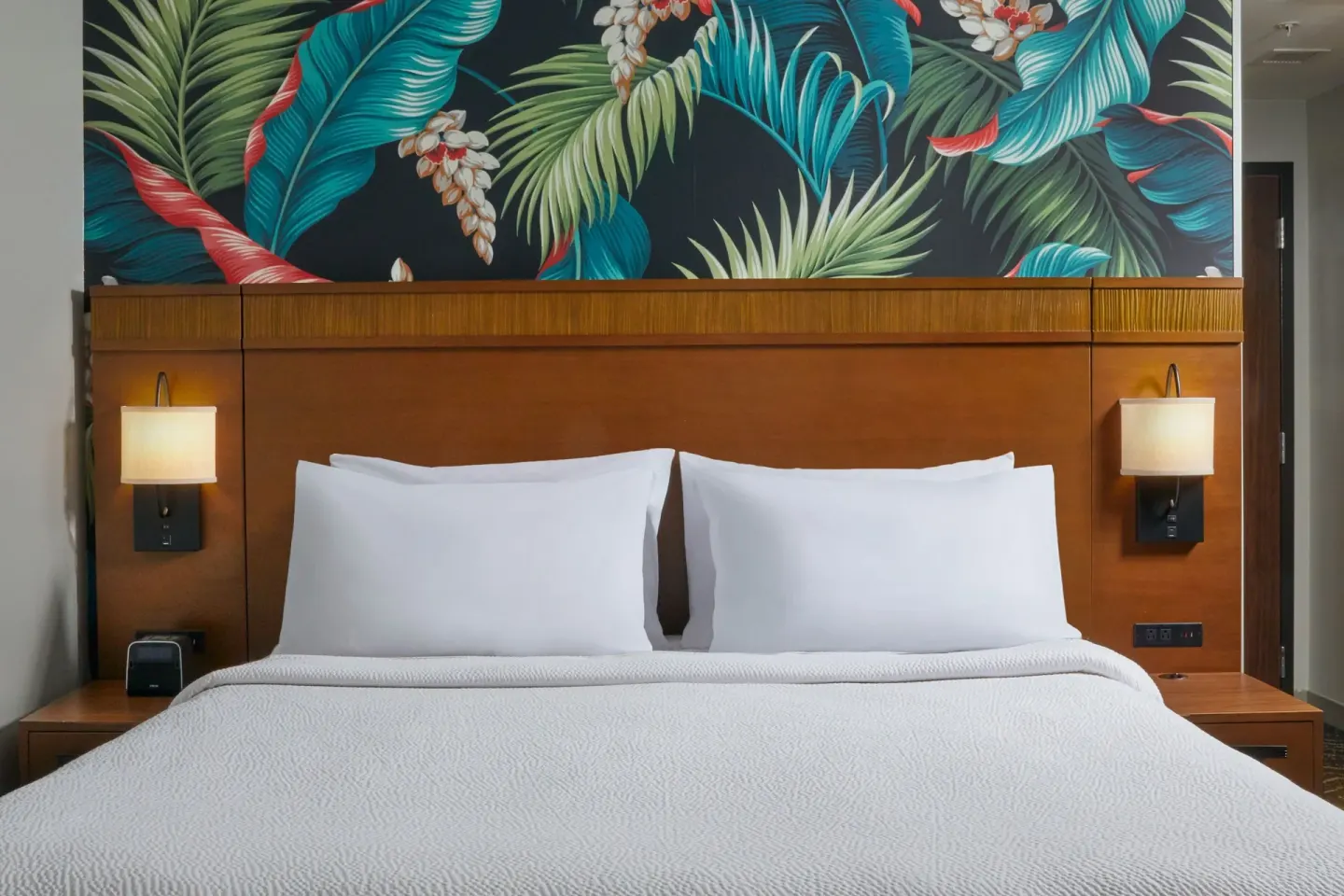 King bed with tropical headboard wall at Courtyard Oahu North Shore.