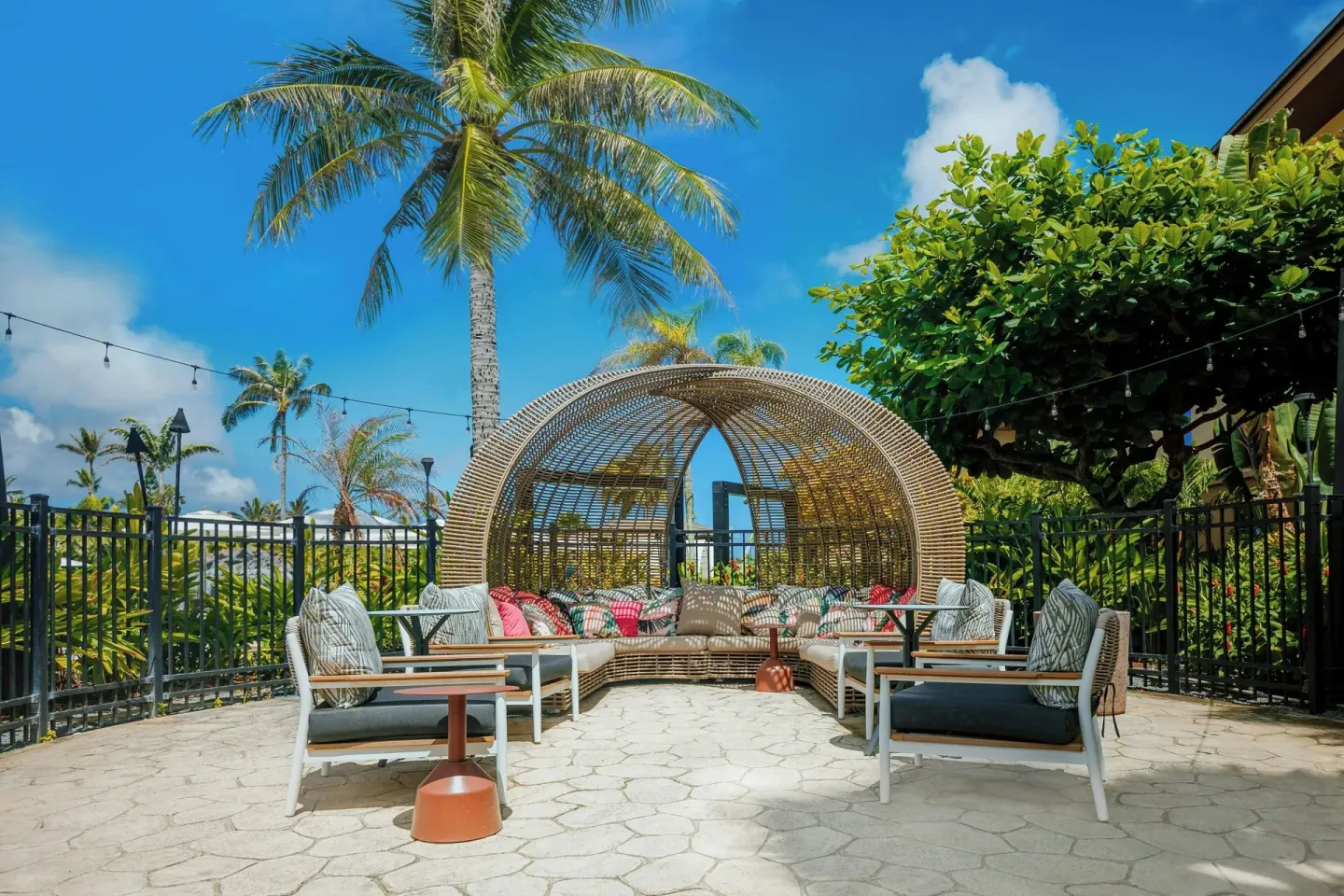 Outdoor lounge seating under palm trees at Courtyard Oahu North Shore.