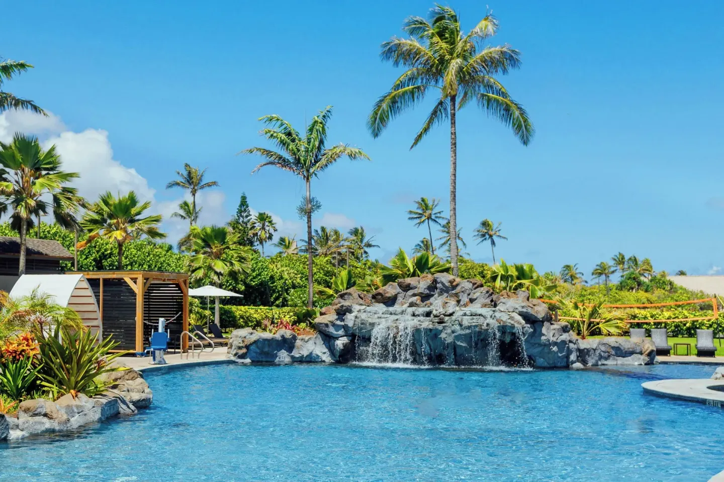 Pool with rock waterfall and palm trees at Courtyard Oahu North Shore.