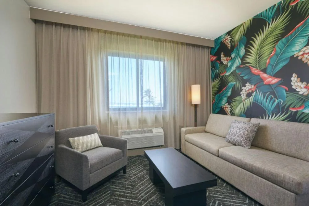 Sofa seating area in a hearing accessible room at Courtyard Oahu North Shore.