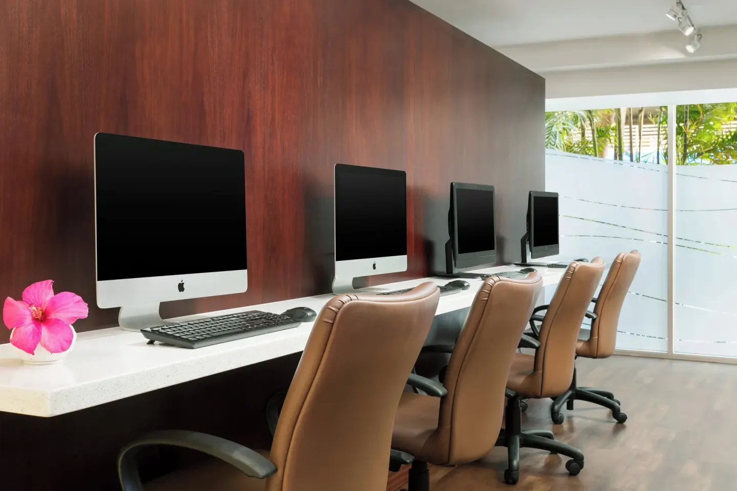 Business center with desktop computers and office chairs at Courtyard Waikiki Beach.