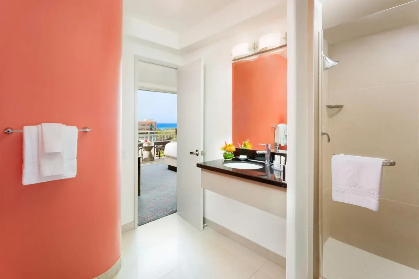 Guest bathroom with coral wall and shower at Courtyard Waikiki Beach.