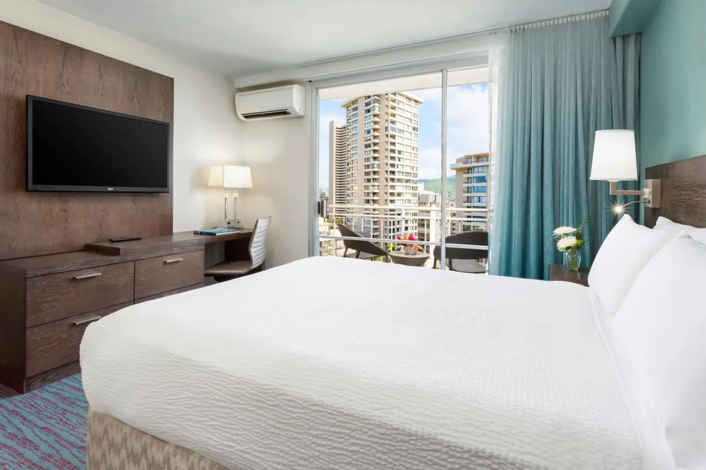King guest room with balcony and city views at Courtyard Waikiki Beach.