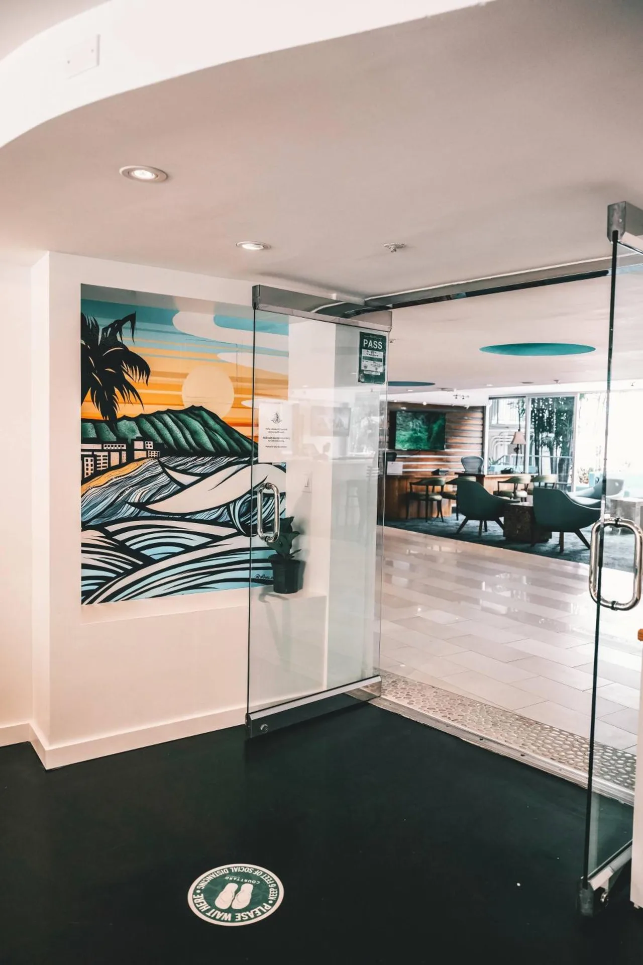 Glass entry doors and mural near the lobby at Courtyard Waikiki Beach.