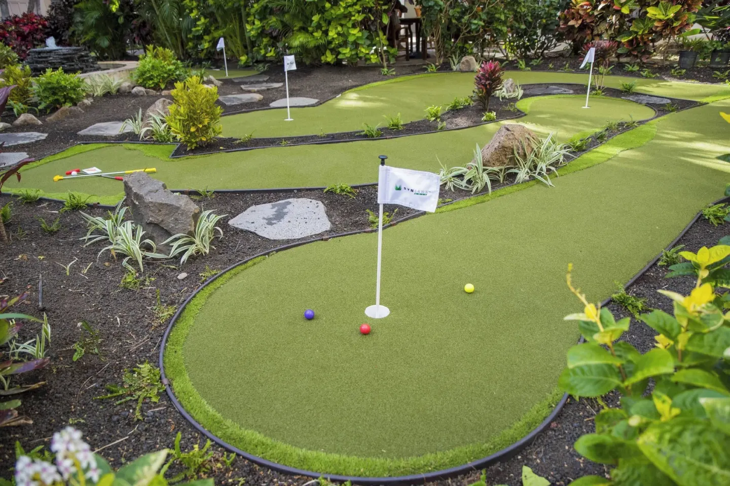 Putting green with flags and colored balls at Courtyard Waikiki Beach.