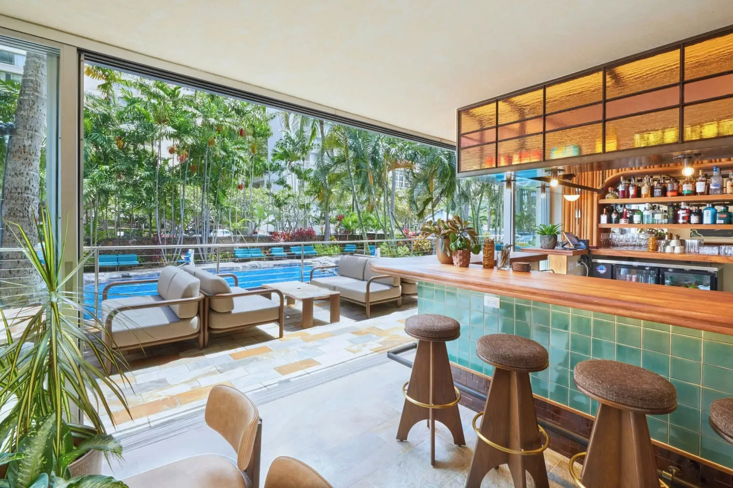 Poolside bar with green tile counter and outdoor seating at Courtyard Waikiki Beach.