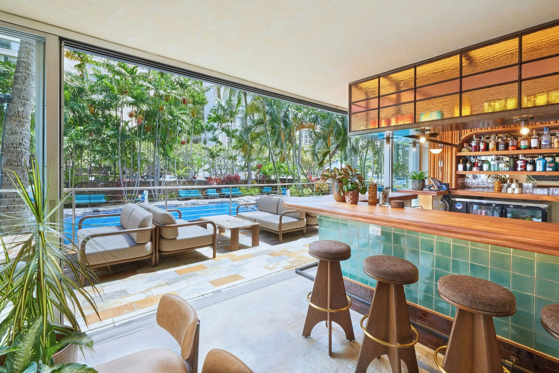 Poolside bar with green tile counter and outdoor seating at Courtyard Waikiki Beach.