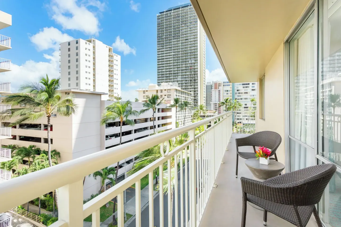 Corner suite balcony with seating and city views at Courtyard Waikiki Beach.