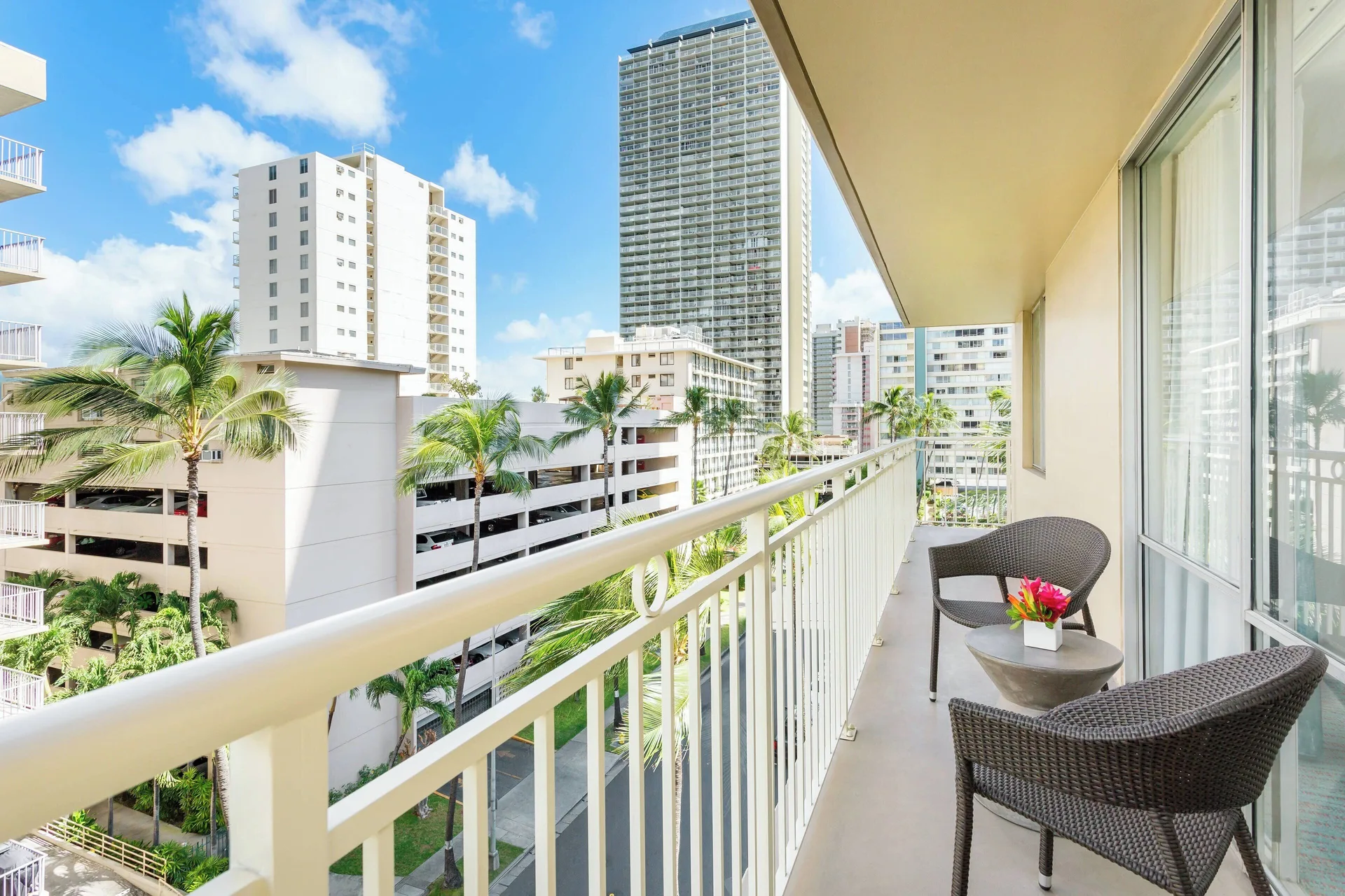 Corner suite balcony with seating and city views at Courtyard Waikiki Beach.