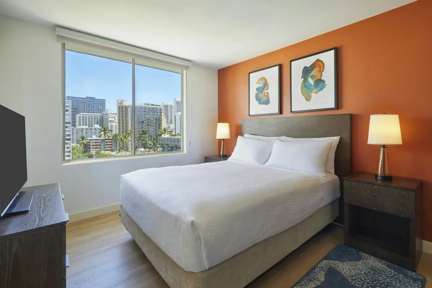 One-bedroom corner suite king bed with city-view window at Courtyard Waikiki Beach.