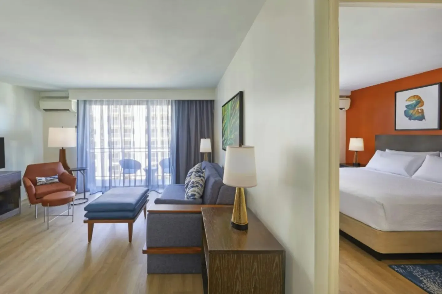 Suite with living area, balcony doors, and separate king bedroom at Courtyard Waikiki Beach.