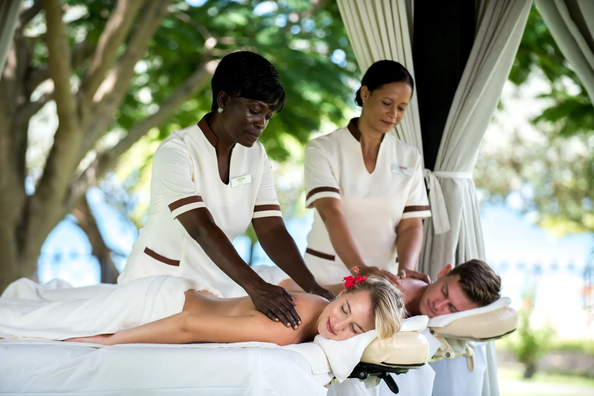Couple receiving side-by-side massages outdoors at Coyaba Beach Resort.
