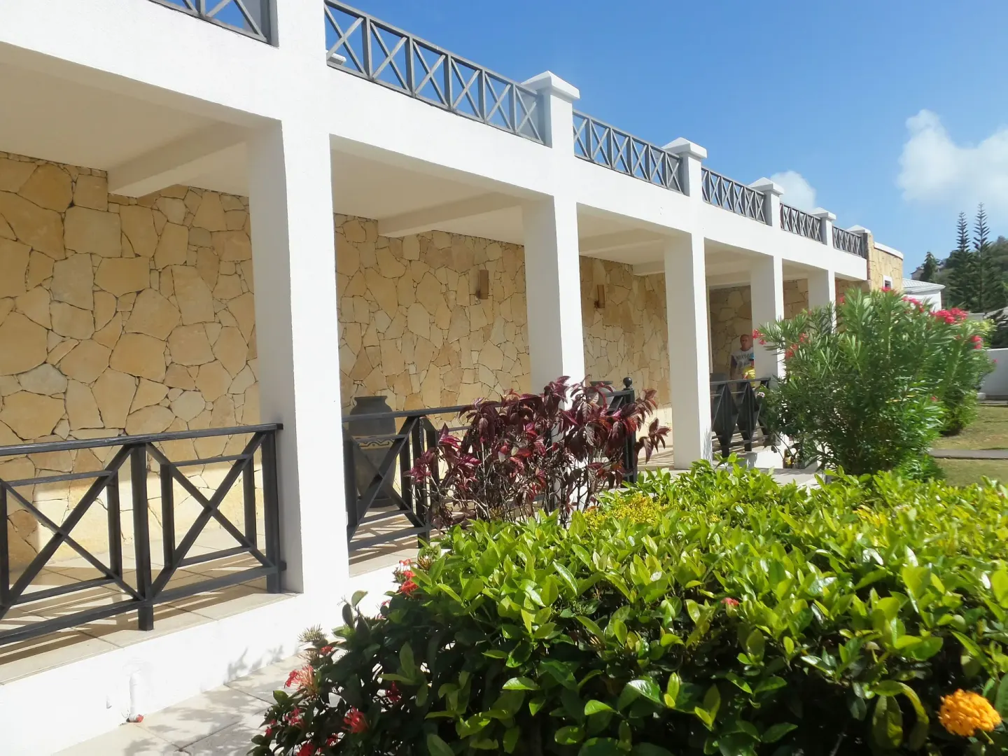 Guest building with stone walls, balconies and tropical plantings at Coyaba Beach Resort.