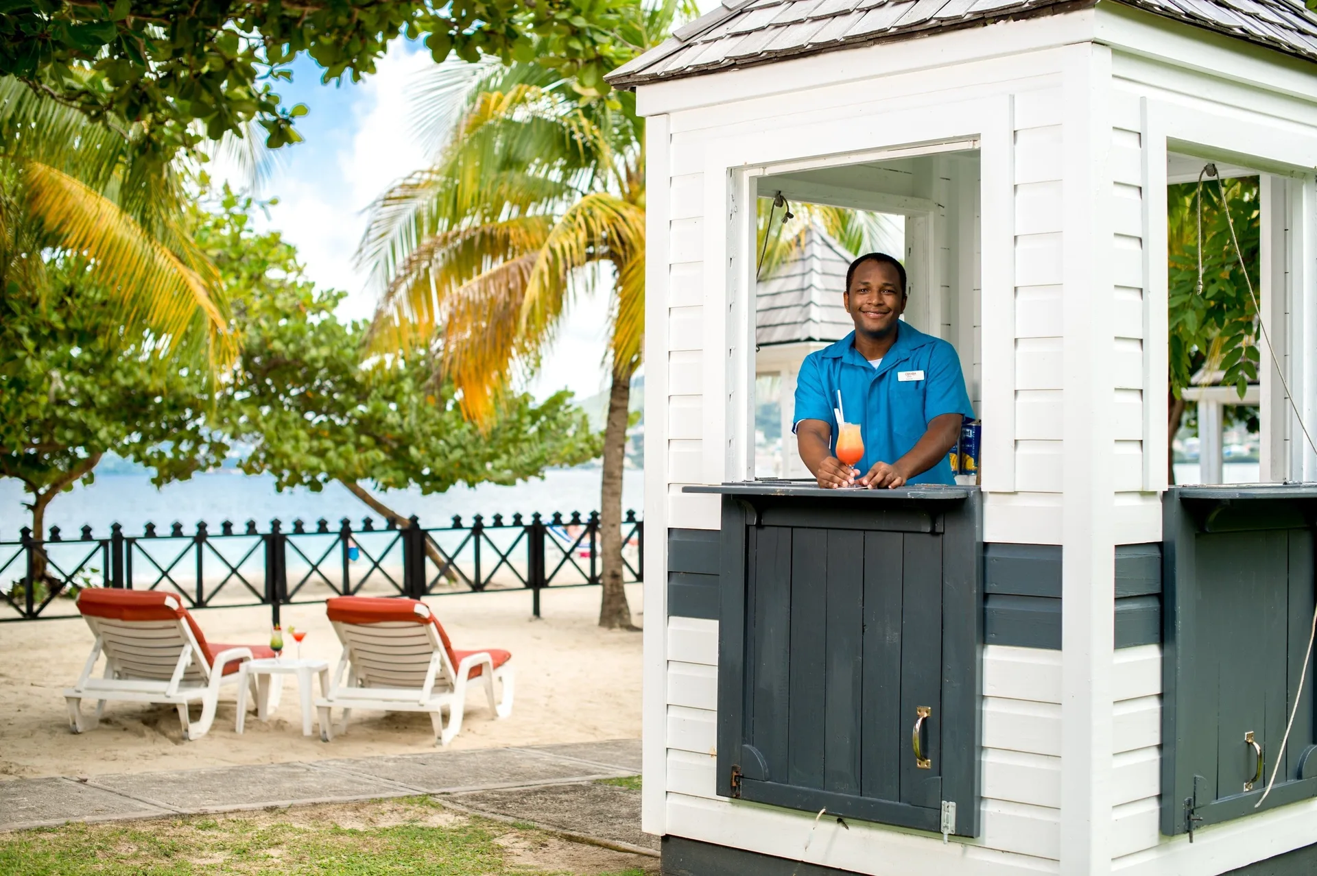 Beach bar hut with staff member by the sand at Coyaba Beach Resort.