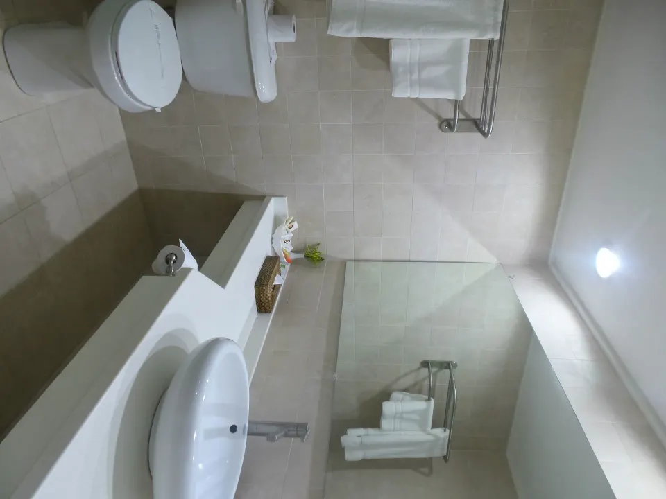 Superior Room bathroom with vanity, towels and glass shower area at Coyaba Beach Resort.