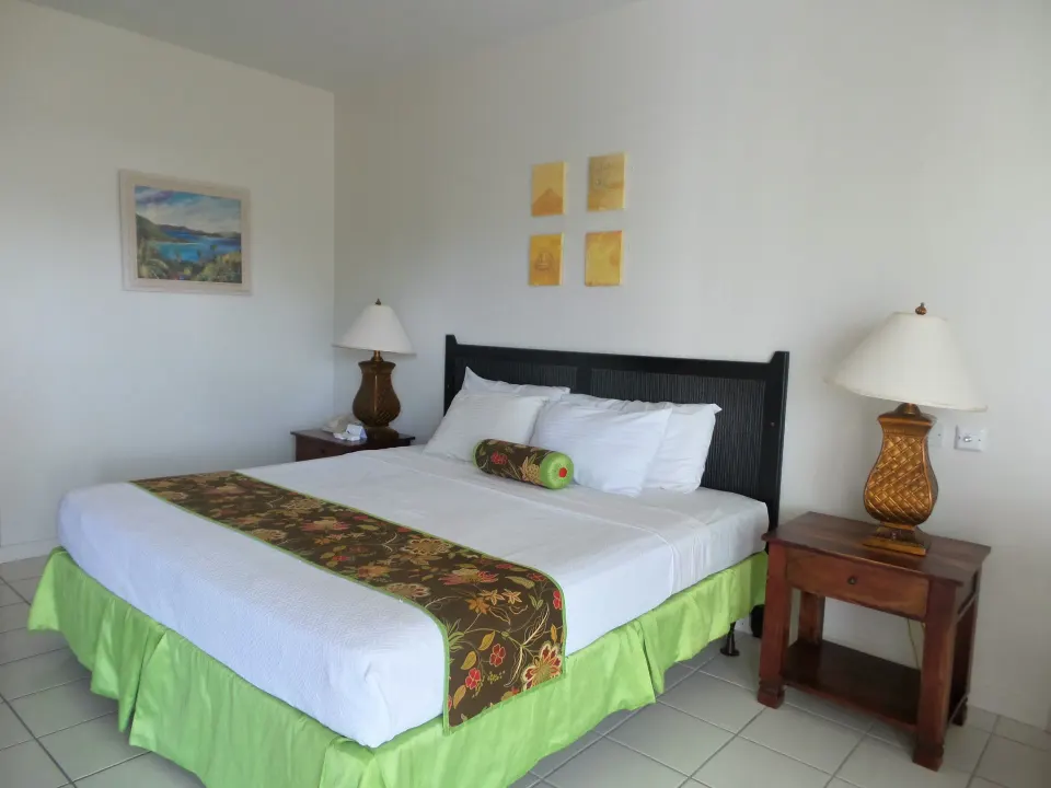 Superior Room king bed with twin nightstands and wall art at Coyaba Beach Resort.