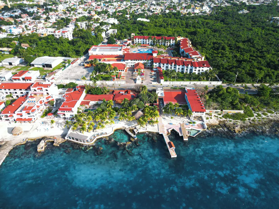 Aerial resort overview showing buildings, pool terraces and coastline at Cozumel Hotel & Resort.