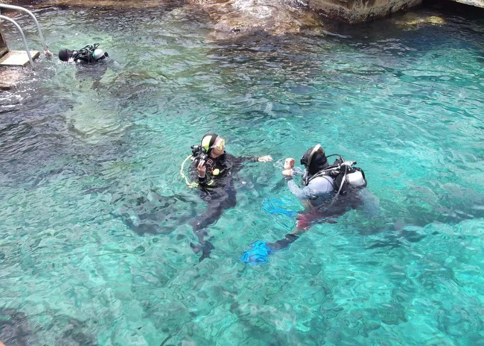 Two scuba divers floating in clear water at Cozumel Hotel & Resort pool area
